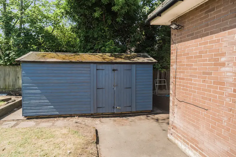 View of the NYCC outdoor renovation with a cornflower blue painted shed